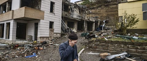 Een oude man loopt langs vernielde gebouwen in de hoofdstad nam Nagorno-Karabach. Armenië en Azerbeidzjan vechten om deze enclave, 6 oktober 2020
