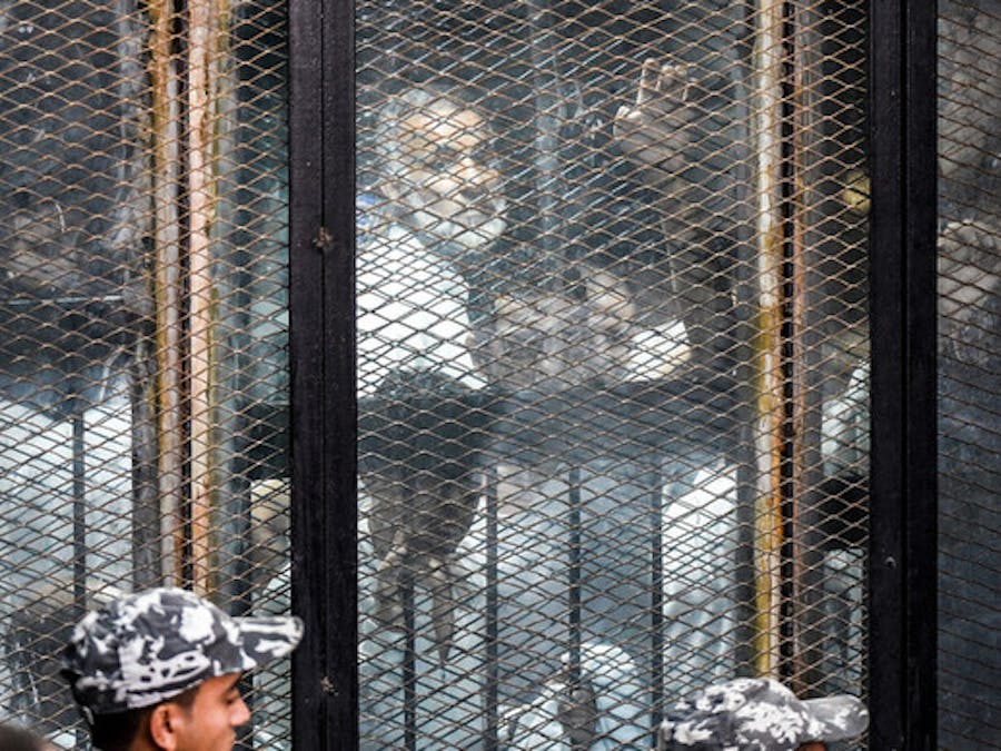 Leden van de verboden Moslimbroederschap in Egypte in een glazen hok tijdens hun proces in de hoofdstad Caïro op 28 juli 2018.