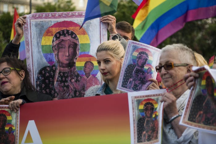 Demonstranten in Polen betuigen steun aan Elzbieta Podlesna, die wordt vervolgd vanwege het verspreiden van afbeeldingen van Maria met een halo in de regenboogkleuren, symbool van de internationale homobeweging.