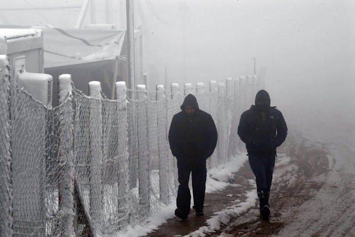 Migranten in de sneeuw bij wat voorheen het kamp Lipa in Bosnië-Herzegovina was, 6 januari 2021