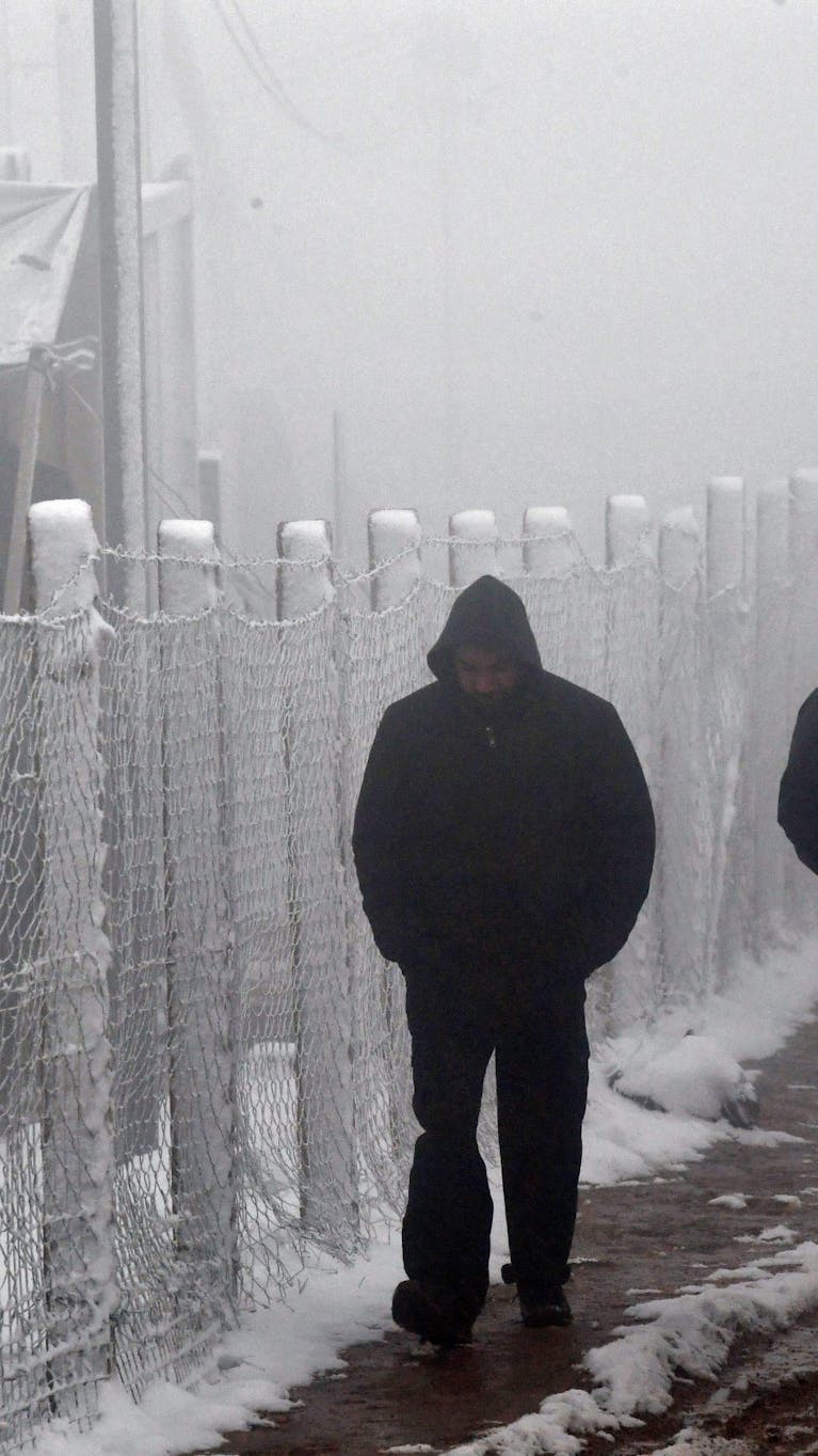 Migranten in de sneeuw bij wat voorheen het kamp Lipa in Bosnië-Herzegovina was, 6 januari 2021