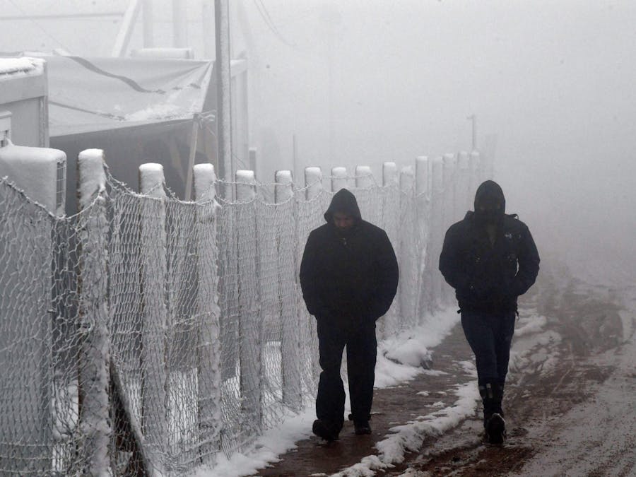 Migranten in de sneeuw bij wat voorheen het kamp Lipa in Bosnië-Herzegovina was, 6 januari 2021