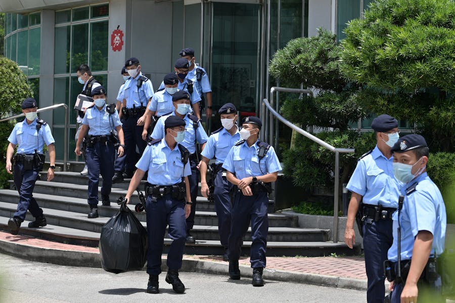 Politieagenten verlaten het gebouw van DAily Apple na een inval op 17 juni 2021