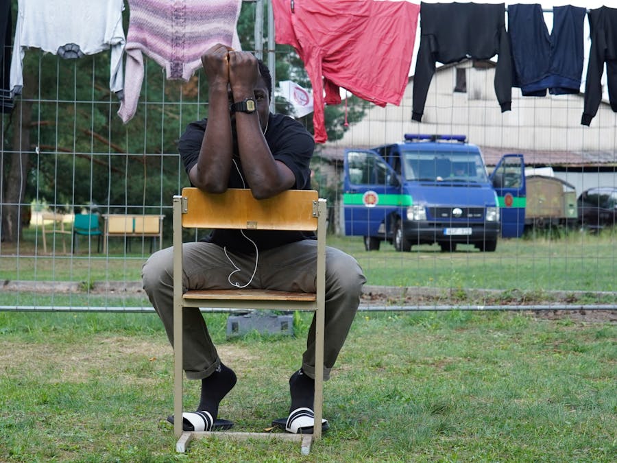 Een man zit op een stoel in een detentiecentrum voor vluchtelingen en migranten in Litouwen