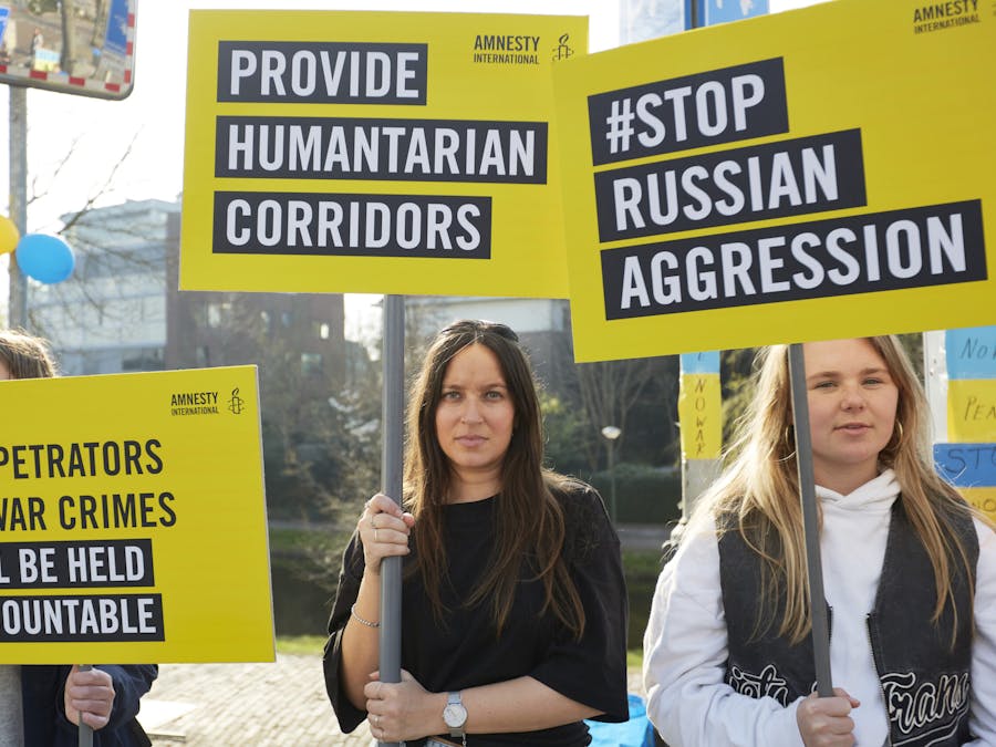Amnesty International-leden en supporters nemen deel aan een actie buiten de Russische ambassade in Den Haag, Nederland, onderdeel van een wereldwijde actiedag om te eisen dat Rusland stopt met zijn invasie van Oekraïne, 24 maart 2022.