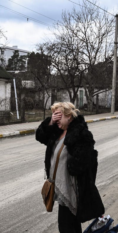 Een vrouw bij een huis in de buurt van Kyiv, Oekraïne, maart 2022.