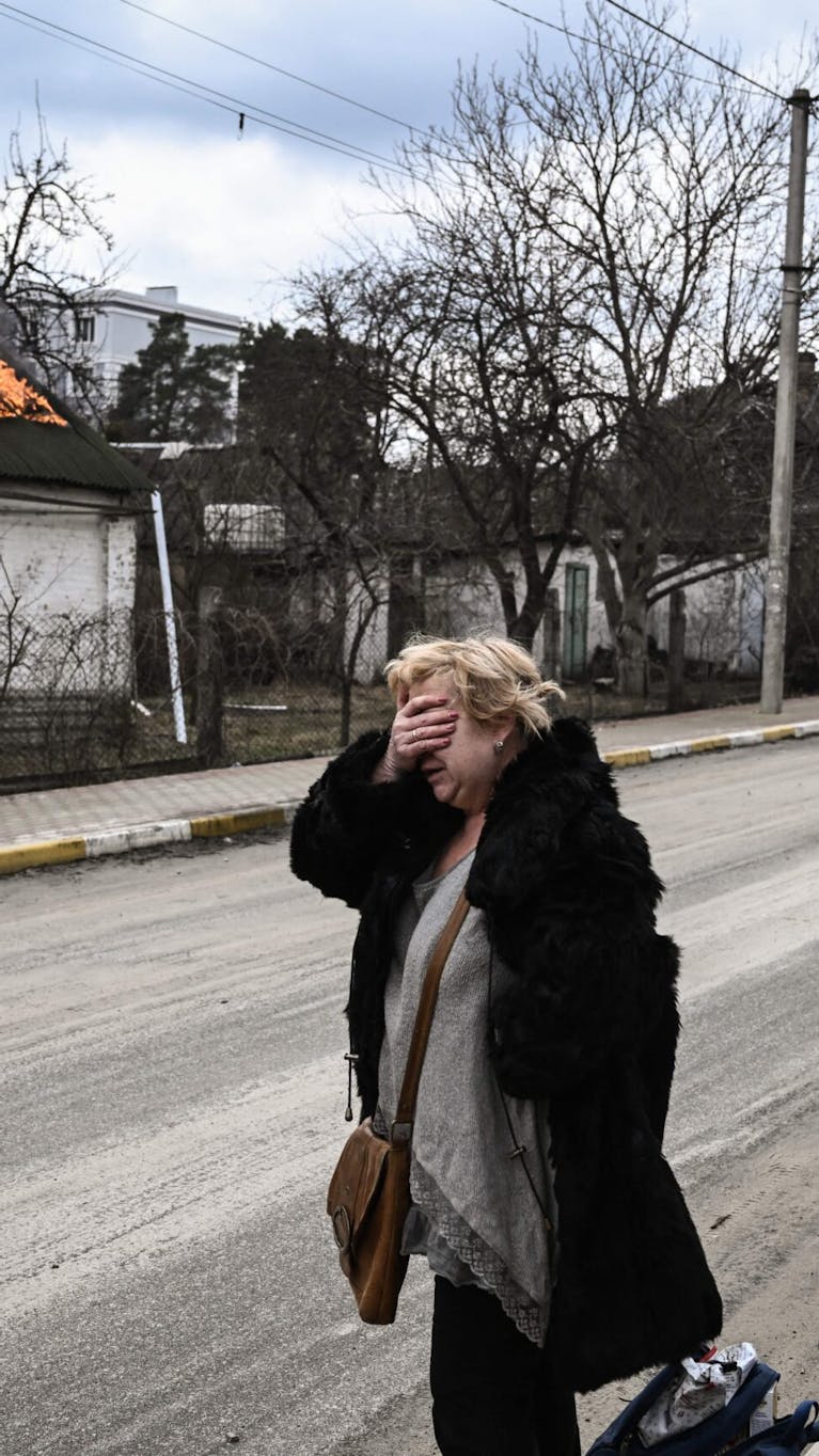 Een vrouw bij een huis in de buurt van Kyiv, Oekraïne, maart 2022.
