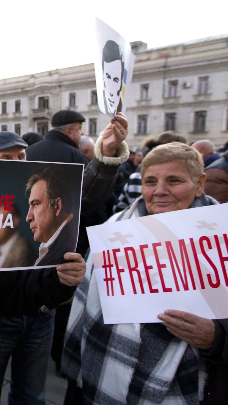 Meerdere aanhangers van de voormalige Georgische president Mikheil Saakashvili hebben zich verzameld voor het regeringsgebouw in Tbilisi, Georgië, op woensdag 4 januari 2023. Ze houden posters vast waarin ze oproepen voor de vrijlating van Saakashvili.
