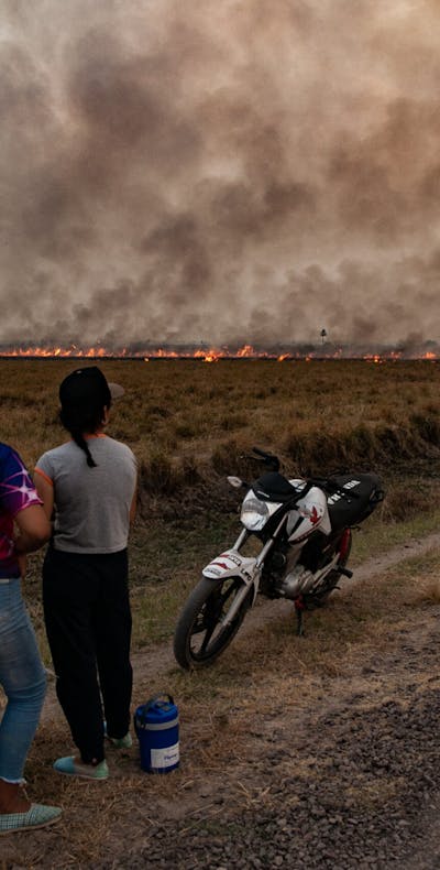 Mensen kijken toe terwijl brandweerlieden en vrijwilligers proberen bosbranden en verwoesting van dieren in het wild tegen te gaan in Corrientes, Argentinië op 19 februari 2022.
