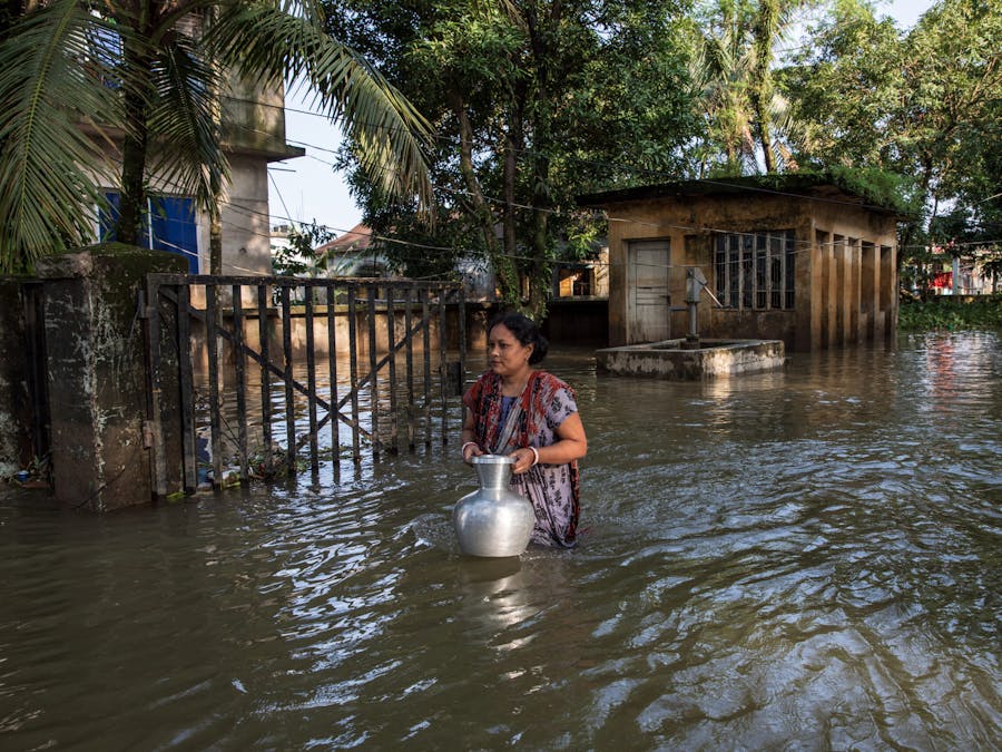 Een vrouw haalt water in een overstroomd gebied in Companiganj, Sylhet, Bangladesh op 22 juni 2022.