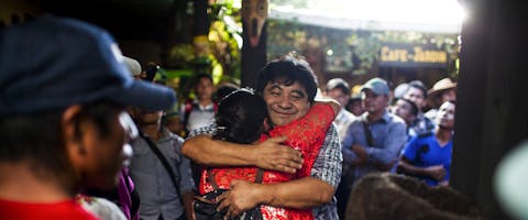 Een lid van het front in verzet tegen de hydro-elektrische dam omhelst Bernardo Caal Xol net buiten de tweede strafrechtbank van eerste aanleg in Cobán, 18 juli 2017.