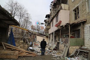 Beschadigd gebouw waar Arkadi Lalayal werd gedood door een raket die op 4 oktober 2020 door Azerbeidzjaanse troepen werd afgevuurd op Stepanakert, die in de tuin voor het gebouw landde.