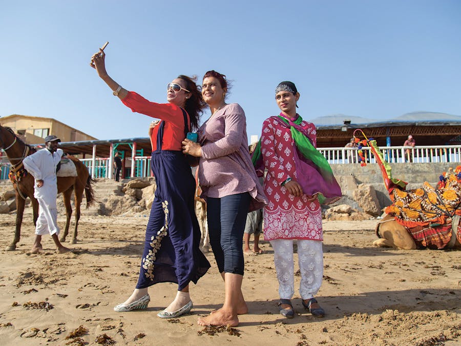 Voorafgaand aan een vrouwenmars verzamelen enkele trans vrouwen zich aan het strand van de Pakistaanse stad Karachi (2021).