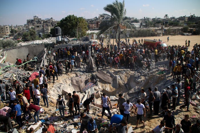 Palestijnse hulpdiensten en burgers zoeken naar slachtoffers bij verwoeste gebouwen in Zuid Gaza.