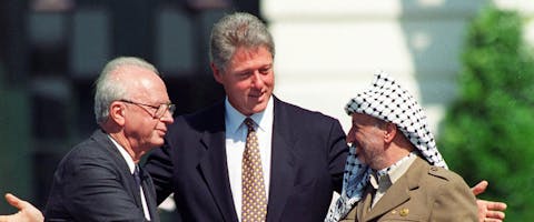 President Clinton met de Israëlische premier Yitzhak Rabin (l) en de Palestijnse leider Yasser Arafat tijdens de historische handdruk in 1993.
