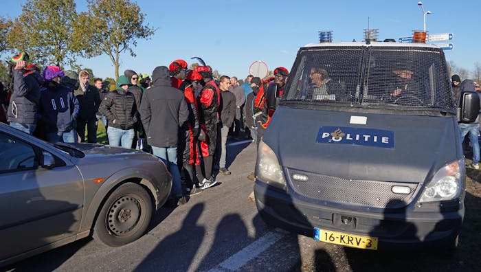 Deelnemers van Kick Out Zwarte Piet bij afrit A28 in Staphorst tegengehouden door menigte tijdens Sinterklaasintocht.