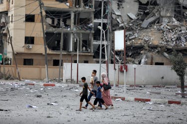 Een Palestijns gezin loopt door de enorme verwoesting veroorzaakt door Israëlische luchtaanvallen in het district al-Rimal in Gaza-stad, op 10 oktober 2023.