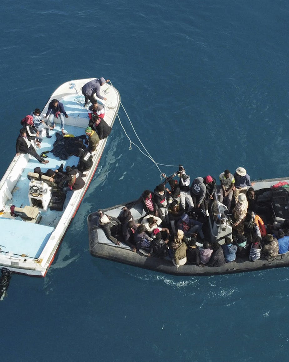 Overlevenden van een schipbreuk waarbij elf mensen verdronken die onderweg waren naar Europa, worden door de Libische kustwacht naar de haven teruggebracht, april 2023.