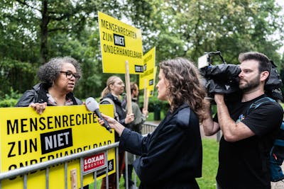 Amnesty International demonstreert voor Paleis Huis ten Bosch tegen mogelijke mensenrechtenschendingen door het nieuwe kabinet. De directeur van Amnesty International wordt geïnterviewd door de pers.