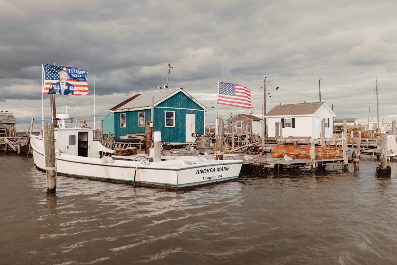 Boven de haven wappert de Amerikaanse vlag met een beelte- ­nis van Donald Trump. In 2020 stemde 87 procent van de inwoners van het eiland Tangier op Trump.