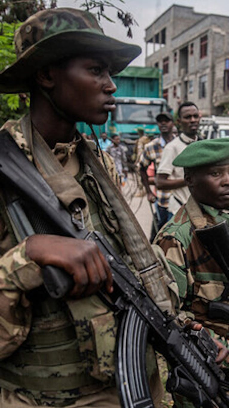 Leden van de M23-beweging staan op wacht voor het konvooi van soldaten van de Democratische Strijdkrachten voor de Bevrijding van Rwanda (FDLR) dat op 1 maart 2025 aankomt bij de belangrijkste grensovergang tussen DR Congo en Rwanda in Goma, tijdens de repatriëring van FDLR-soldaten door de M23-beweging naar Rwanda. (Foto door Jospin Mwisha / AFP) (Foto door JOSPIN MWISHA/AFP via Getty Images)