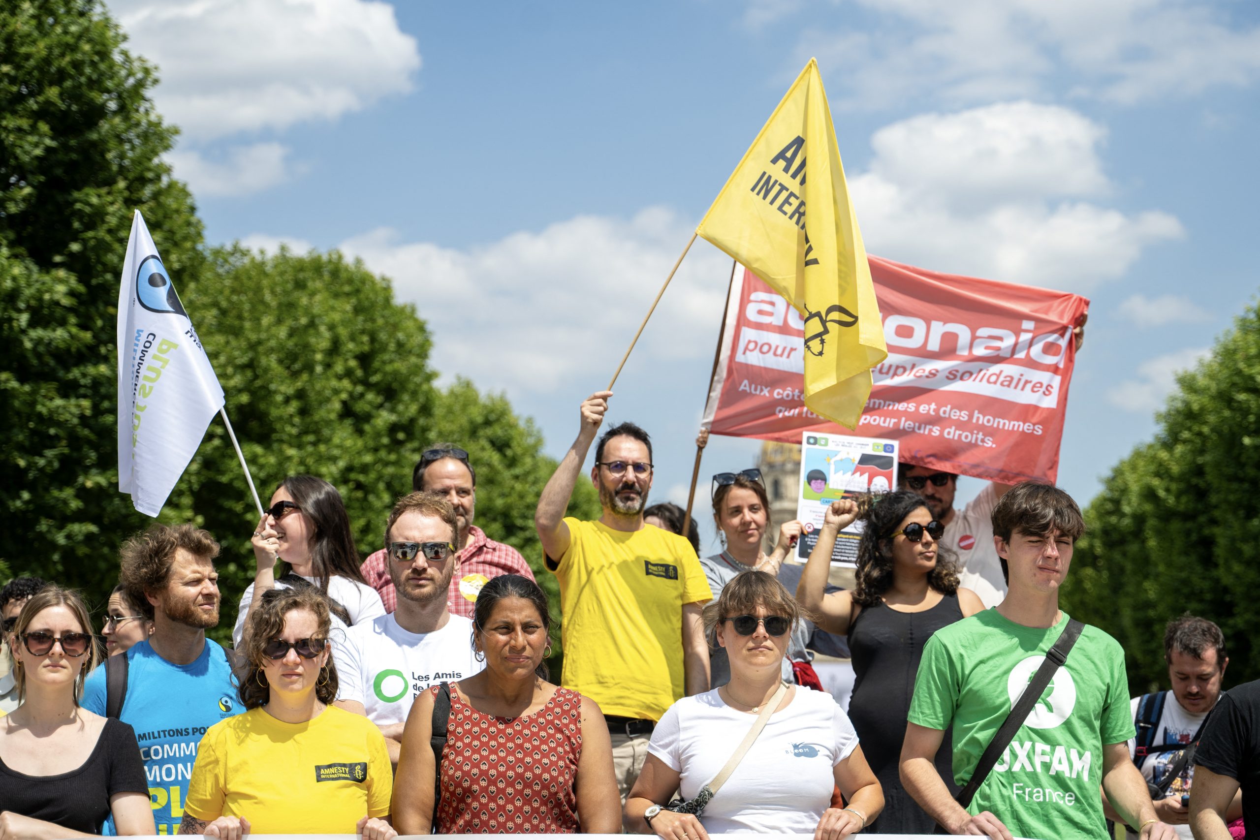 Activisten nemen deel aan een symbolische actie van Amnesty International Frankrijk en andere ngo's tegen de Europese omnibusrichtlijn, een pakket maatregelen om de sociale en milieuwetgeving voor bedrijven te vereenvoudigen, in Parijs op 17 juni 2025. Ongeveer vijftien organisaties, waaronder Amnesty International Frankrijk, Oxfam Frankrijk, CCFD, Notre Affaire a Tous, Greenpeace, FIDH, Friends of the Earth, Sherpa en Bloom, namen deel aan de actie. De omnibusrichtlijn, die in februari 2025 door de Europese Commissie werd gepresenteerd, werd positief onthaald door werkgeversorganisaties, met name in Frankrijk. (Foto door EMMA DA SILVA / AFP) (Foto door EMMA DA SILVA/AFP via Getty Images)