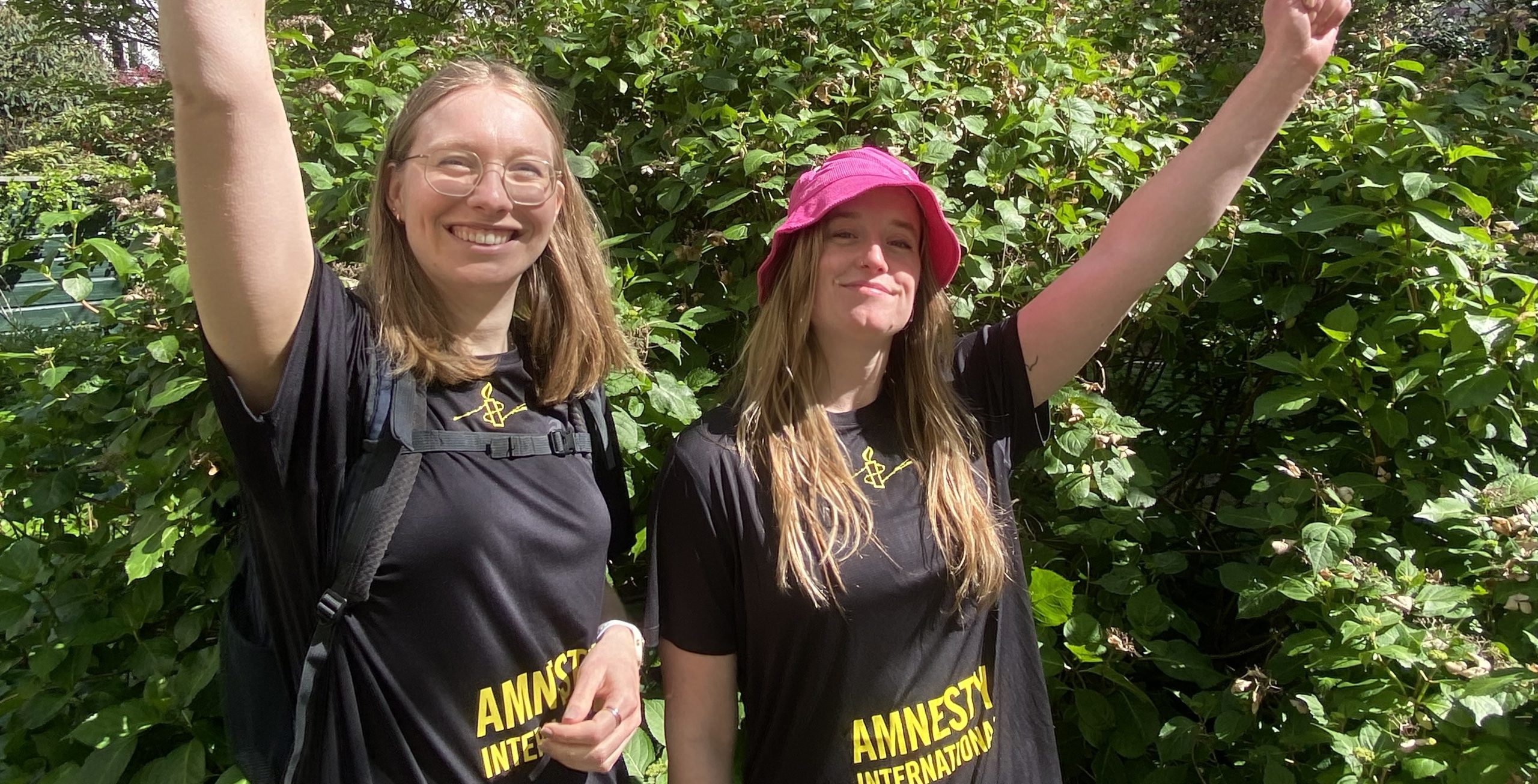 Twee wandelaars tijdens de Vierdaagse lopen in een Amnesty-shirt