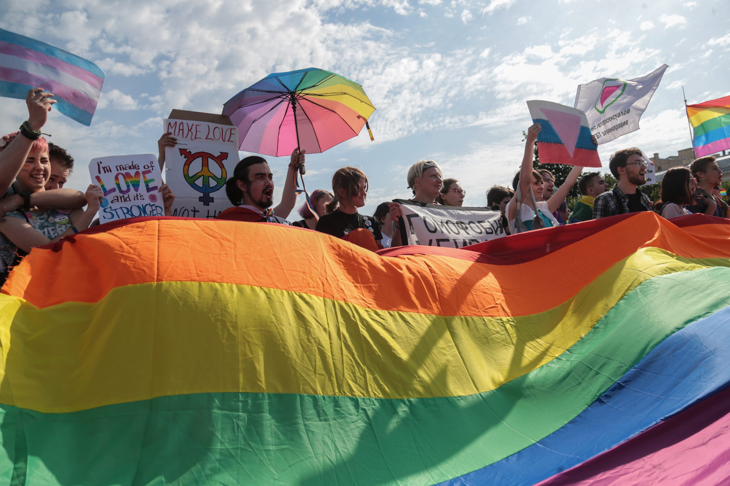 ST. PETERSBURG, RUSLAND - 12 augustus 2017: Deelnemers houden een regenboogvlag vast, beter bekend als de LGBT-pridevlag, tijdens de Gay Pride-demonstratie op het Marsveld. Enkele tientallen mensen kwamen naar het Marsveld in Sint-Petersburg om deel te nemen aan de VIIIe LGBT Pride van Sint-Petersburg.