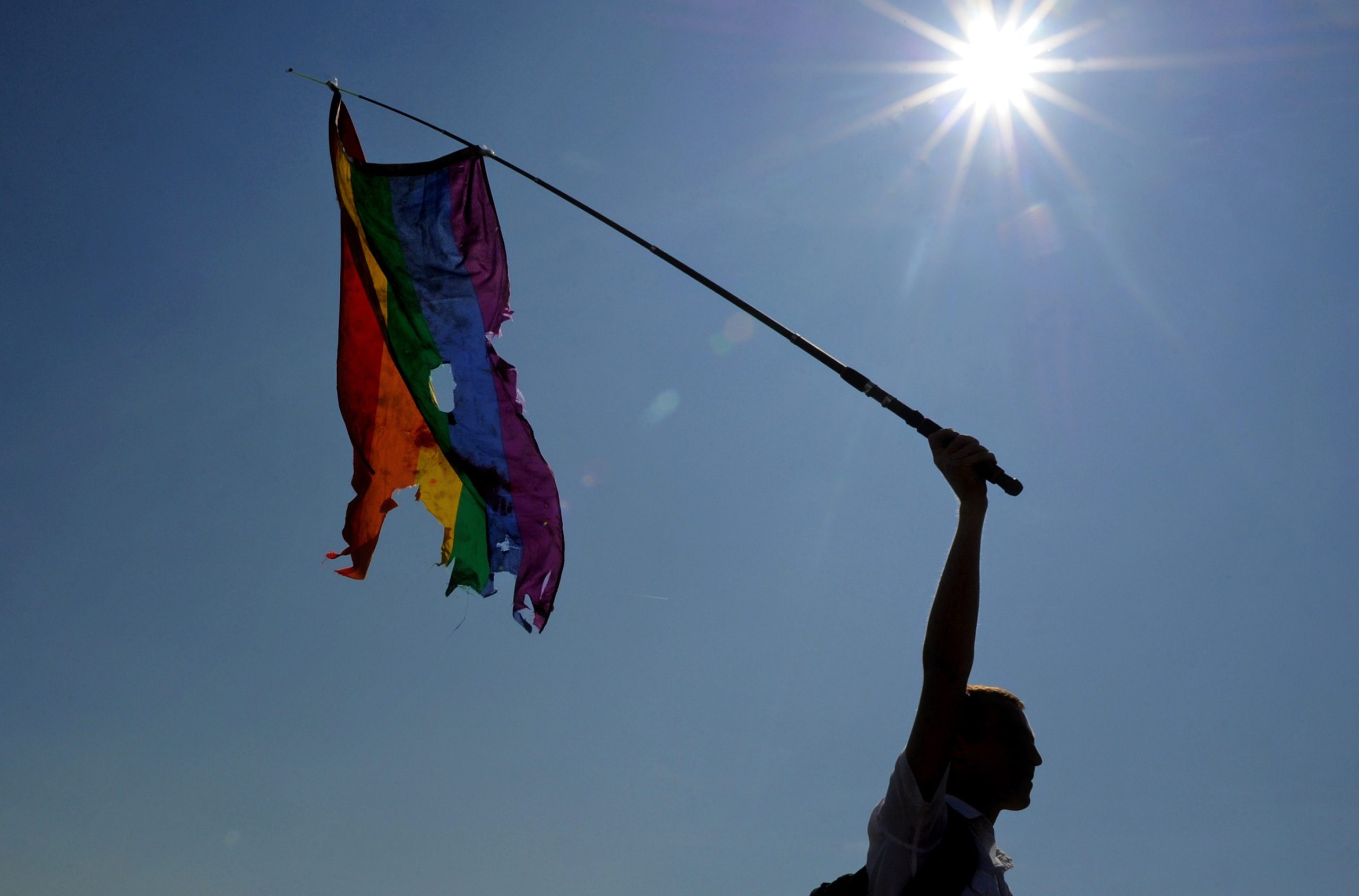 Een lhbti-rechtenactivist zwaait met een beschadigde regenboogvlag tijdens een gay pride-optocht in Sint-Petersburg op 26 juli 2014. AFP PHOTO / OLGA MALTSEVA (Foto: OLGA MALTSEVA/AFP/Getty Images)