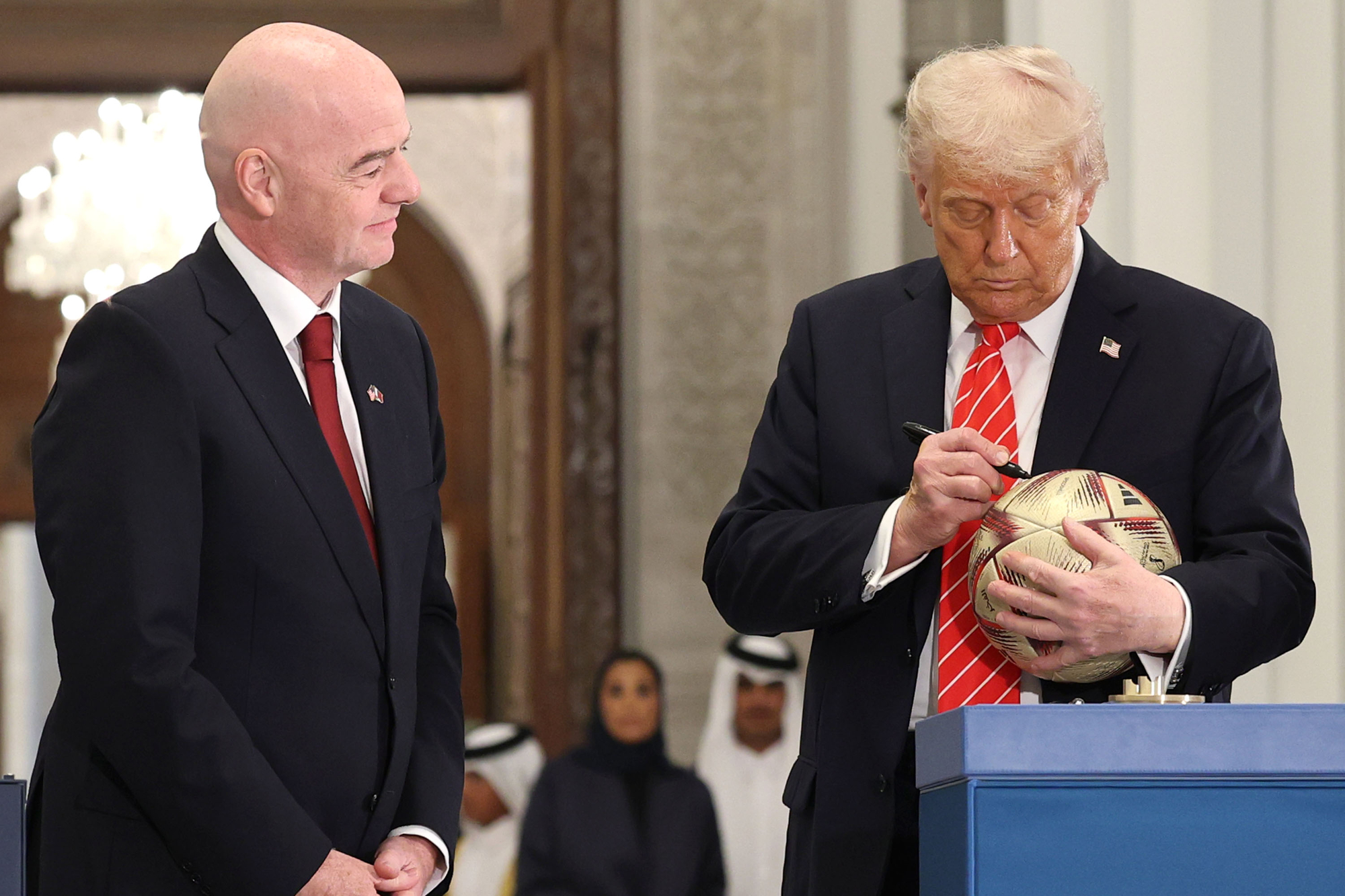 DOHA, QATAR - MAY 14: (L-R) FIFA President Gianni Infantino and U.S. President Donald J. Trump sign a football during a World Cup 2026 ceremony after a state dinner at the Lusail Palace on May 14, 2025, in Doha, Qatar. The visit underscores the strategic partnership between the United States and Qatar, focusing on regional security and economic collaboration. (Photo by Win McNamee/Getty Images)