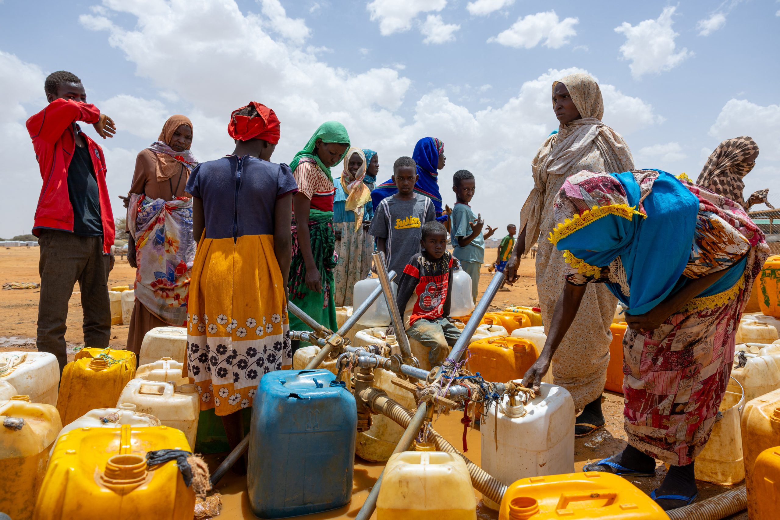 Sudanese vluchtelingen vullen jerrycans met water in het vluchtelingenkamp Touloum in de provincie Wadi Fira, Tsjaad, op 8 april 2025. De burgeroorlog in Sudan heeft geleid tot „13 miljoen ontheemden en vluchtelingen”, waaronder veel vrouwen die aangaven te zijn verkracht en kinderen, zo vertelde een regionale UNHCR-functionaris op 14 april 2025 aan AFP. “Het conflict heeft geleid tot de ontheemding van 13 miljoen mensen, waaronder 8,6 miljoen binnenlandse ontheemden en 3,8 miljoen vluchtelingen”, zei Abdourahouf Gnon-Konde van het VN-vluchtelingenagentschap in een interview na een bezoek aan het door oorlog verscheurde land. (Foto door Joris Bolomey / AFP) (Foto door JORIS BOLOMEY/AFP via Getty Images)