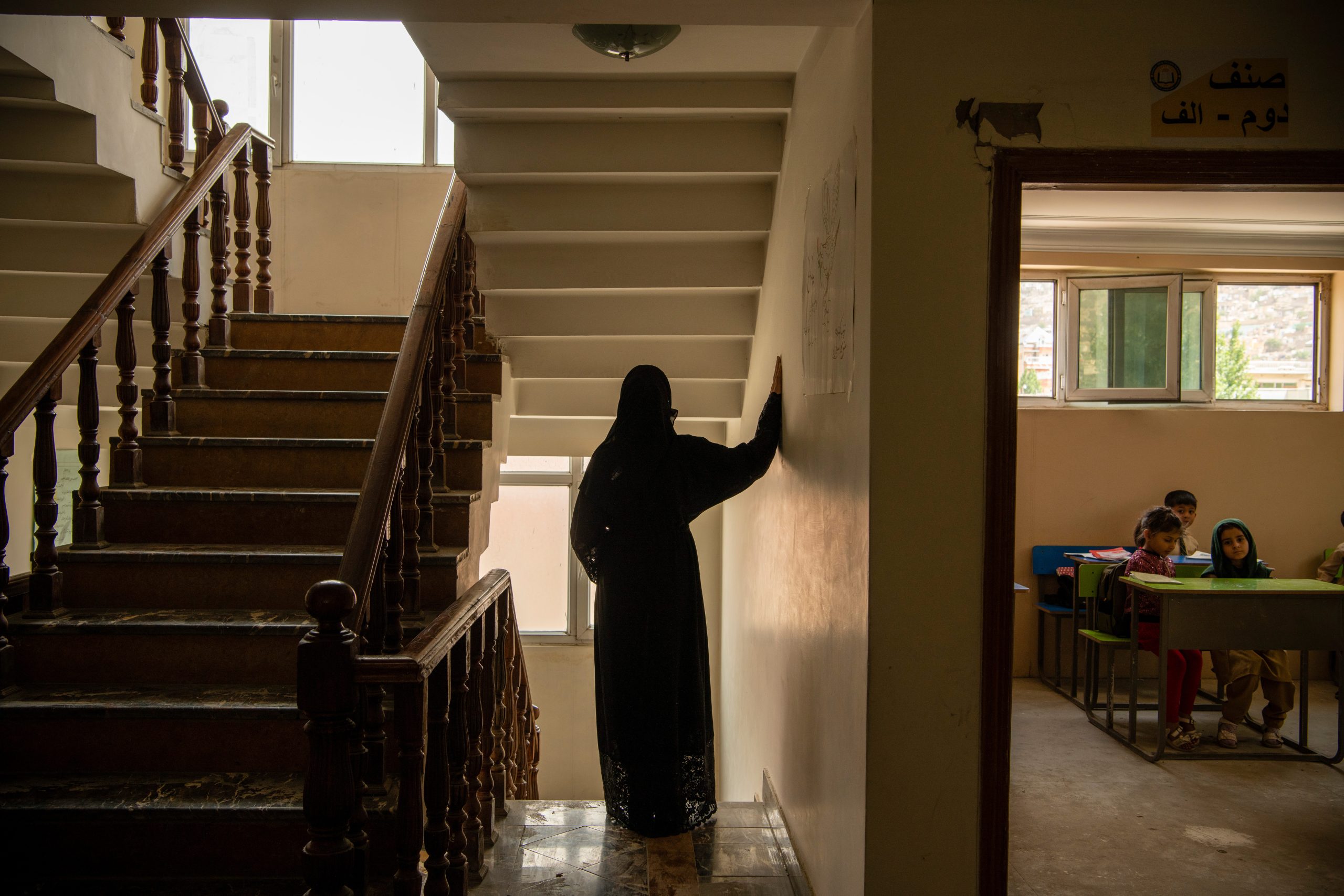 Afghaanse vrouw poseert voor foto in haar werkomgeving.