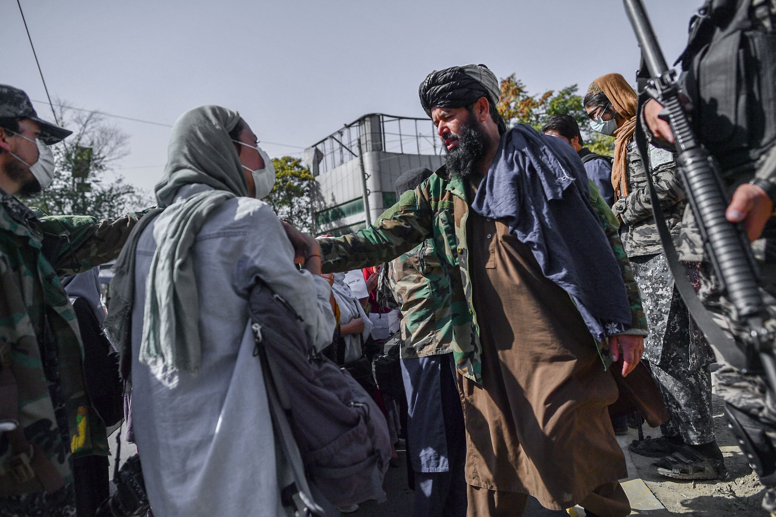 Taliban members stop women protesting for women's rights in Kabul on October 21, 2021. - The Taliban violently cracked down on media coverage of a women's rights protest in Kabul on October 21 morning, beating several journalists. (Photo by BULENT KILIC / AFP) (Photo by BULENT KILIC/AFP via Getty Images)