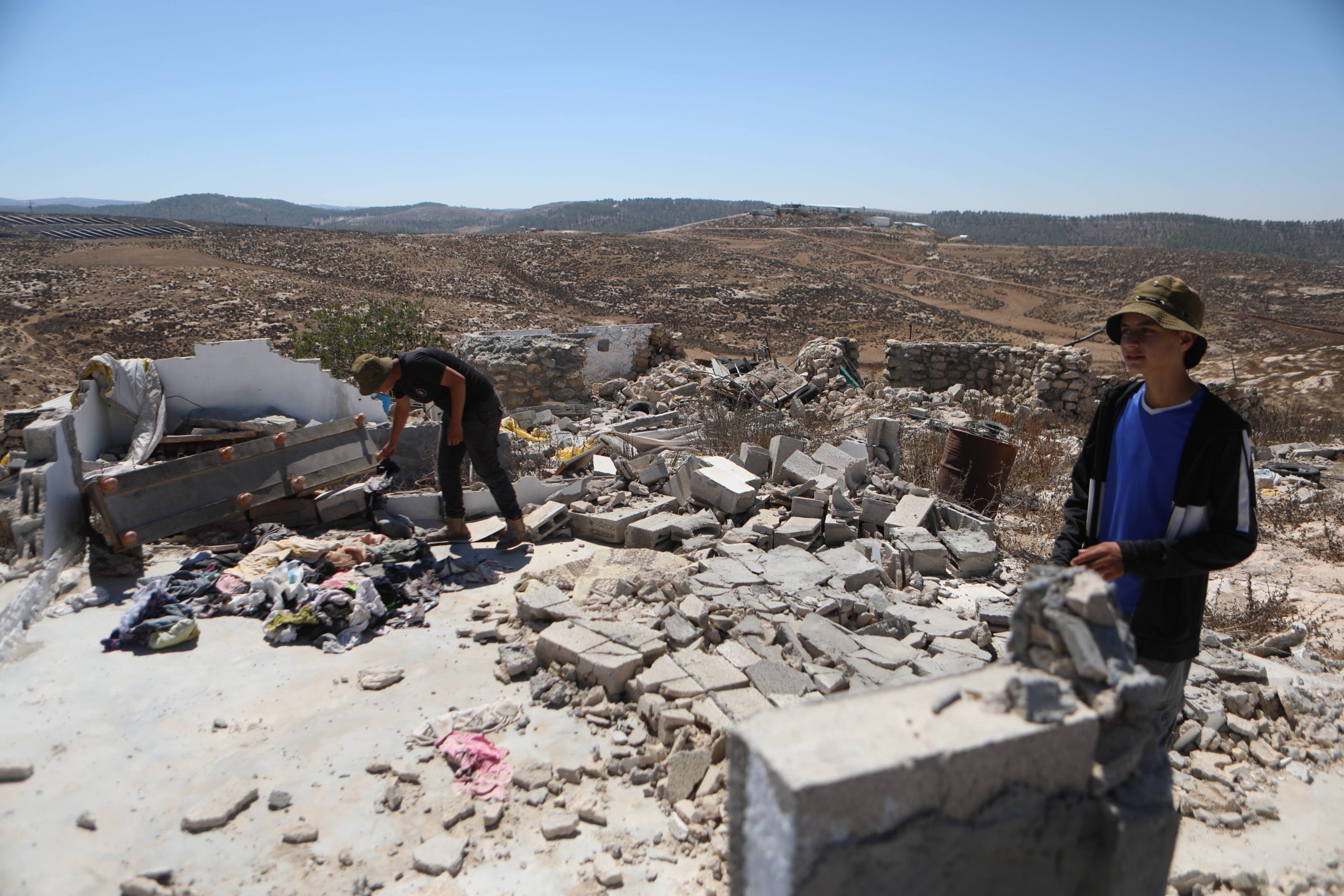Inwoners van Zanuta inspecteren de schade na een aanval van Israëlische kolonisten in 2024.