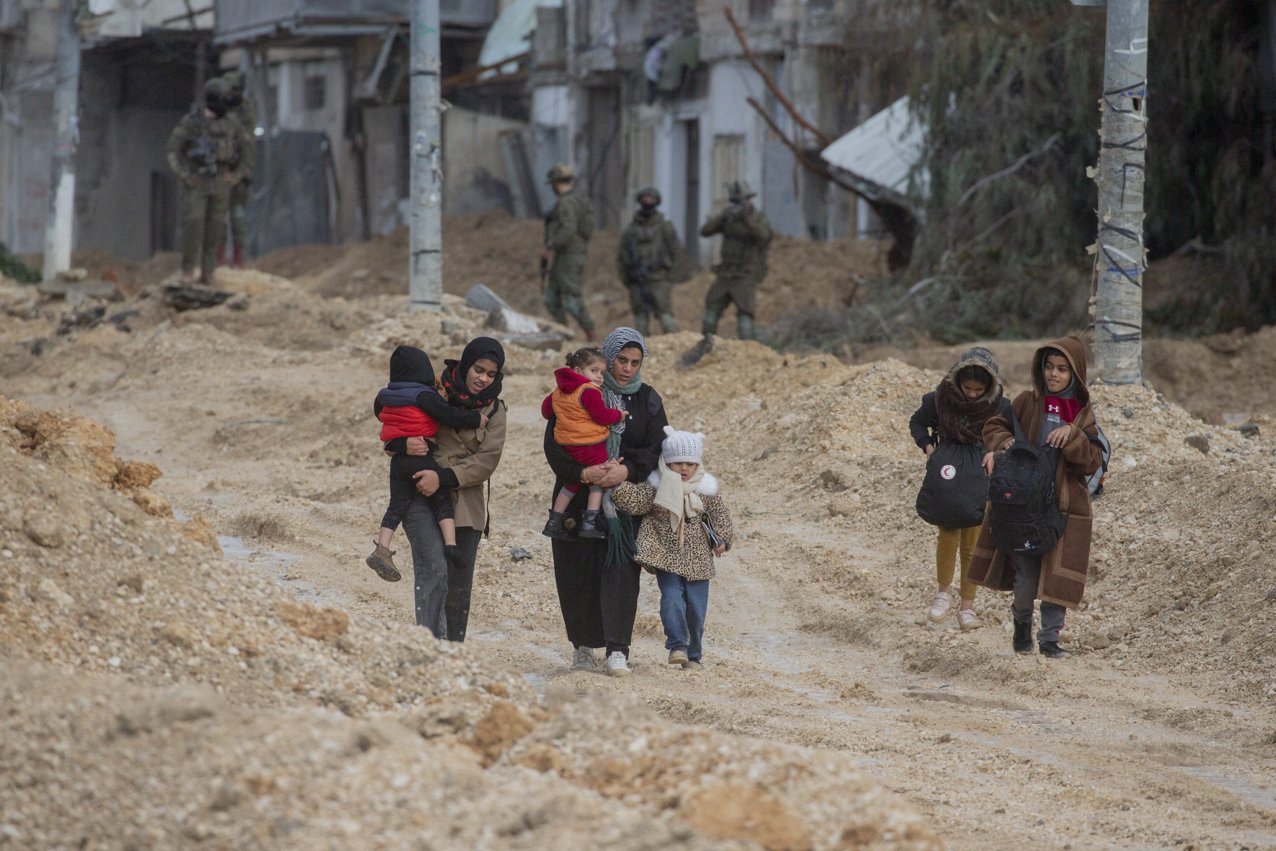 Groep vrouwen en kinderen lopen in het Palestijnse vluchtelingenkamp Nur Shams.