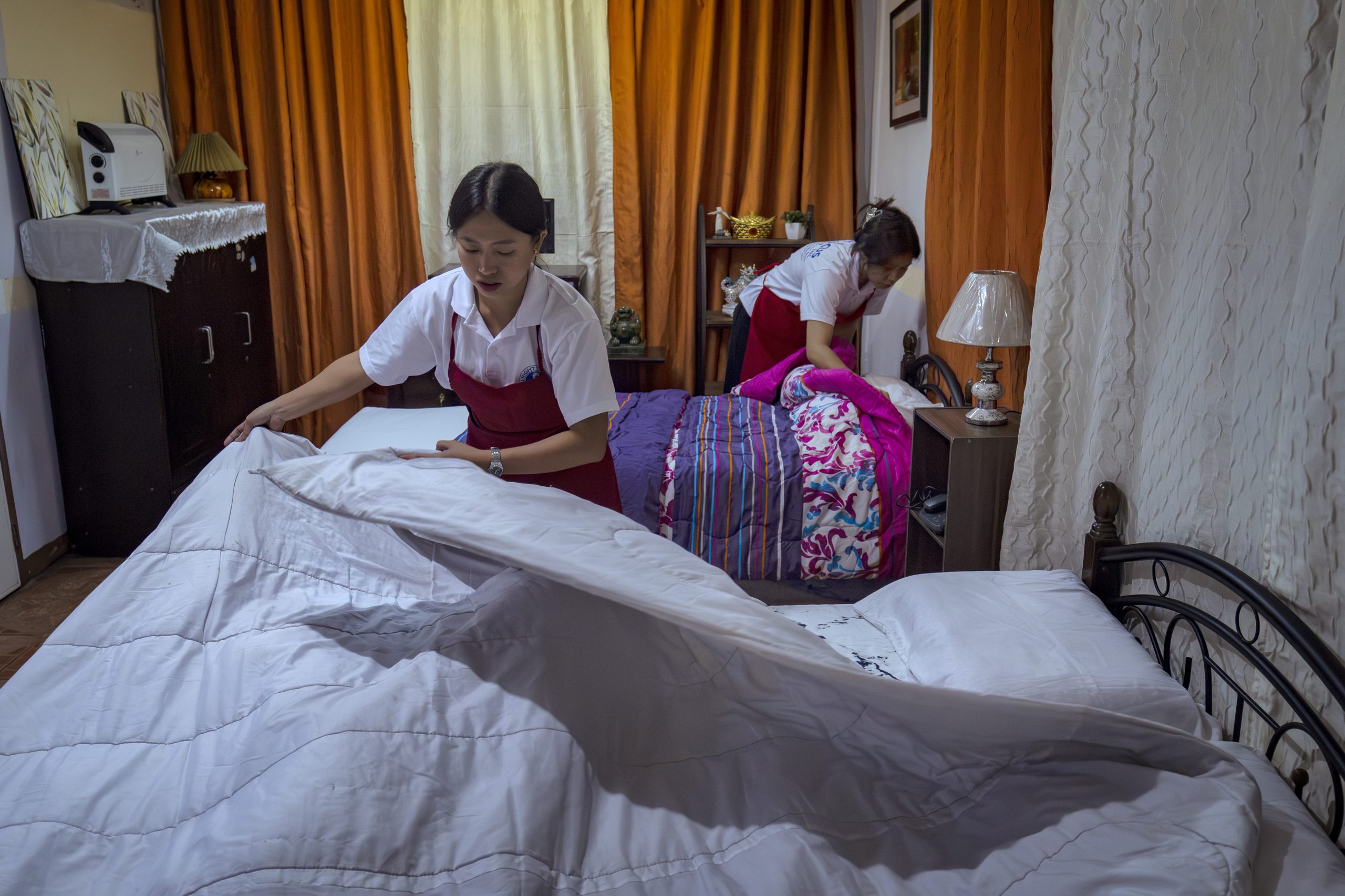 Huishoudelijk hulpen in opleiding worden klaargestoomd in een trainingscentrum in Manila, Filippijnen, voor werk in het buitenland.