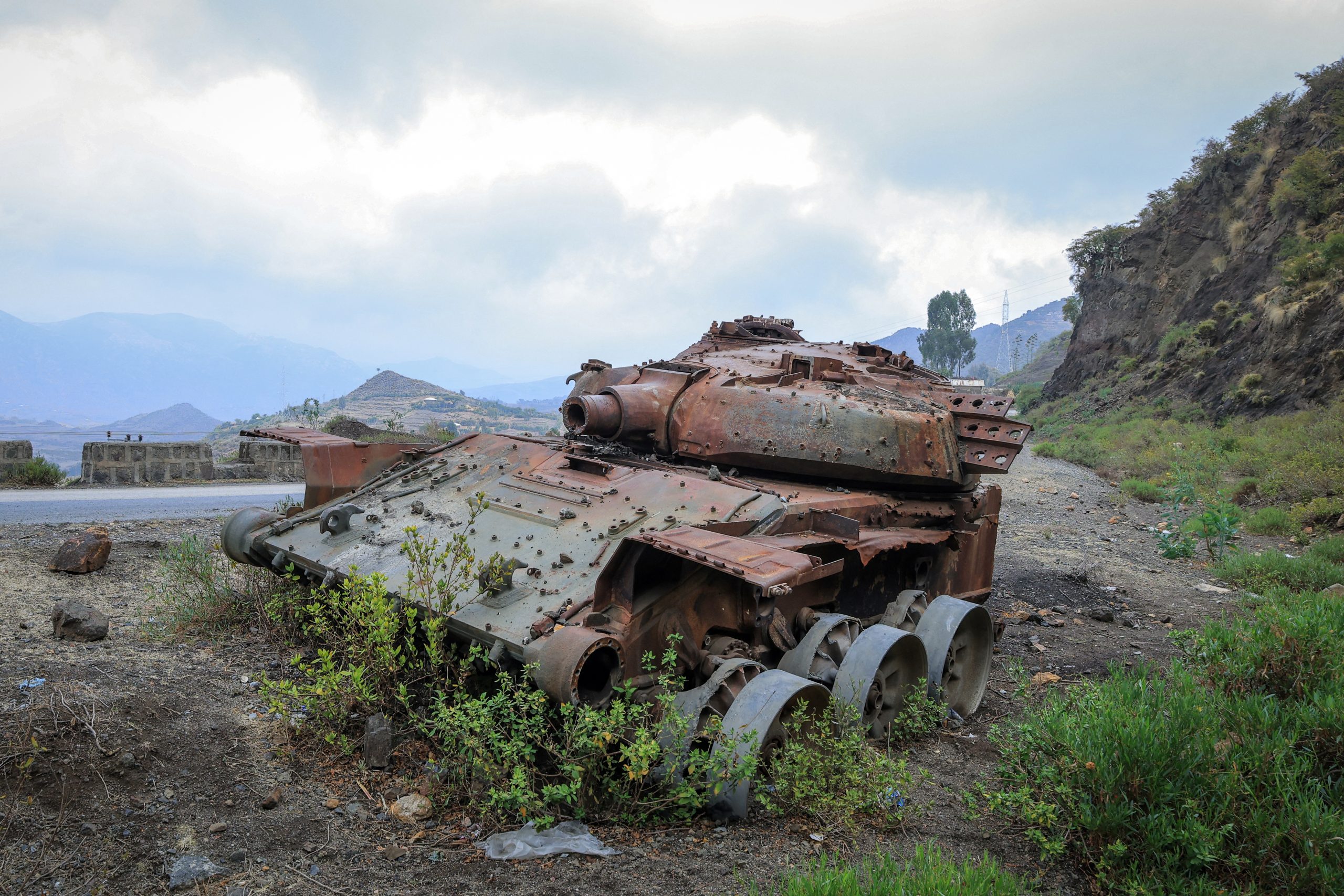 De verkoolde resten van een tank uit de gevechten tussen de ENDF en het Tigray People’s Liberation Front (TPLF) liggen op 3 maart 2026 op een weg nabij Gereb Agew, in Zuid-Tigray. Terwijl een groot deel van het Midden-Oosten in brand staat door de oorlog, dreigt er net aan de overkant van de Rode Zee een nieuw conflict in de Hoorn van Afrika. Federale en Tigrayaanse troepen verzamelen zich opnieuw aan hun gezamenlijke grens in het noorden van Ethiopië. Het vredesakkoord dat in 2022 een einde maakte aan de laatste burgeroorlog, is nooit naar behoren uitgevoerd en de betrekkingen zijn uiterst onstabiel gebleven, wat niet wordt geholpen door de verslechterende relaties van Ethiopië met Eritrea, dat aan Tigray grenst. Abel Gerezgiher / AFP