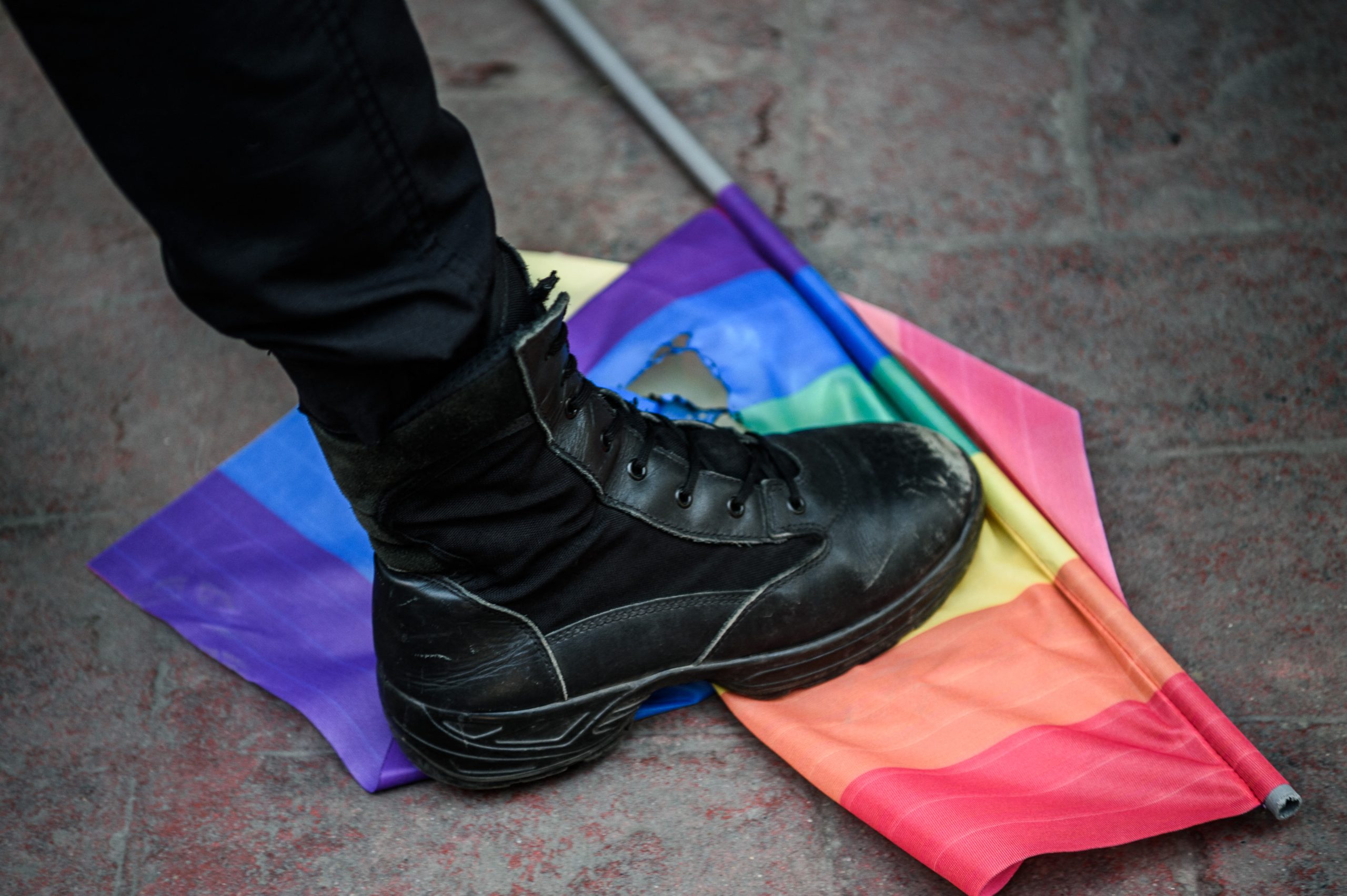 Agent van de Turkse oproerpolitie vertrapt een regenboogvlag tijdens een lhbtqia+-mars in Istanbul in 2016.