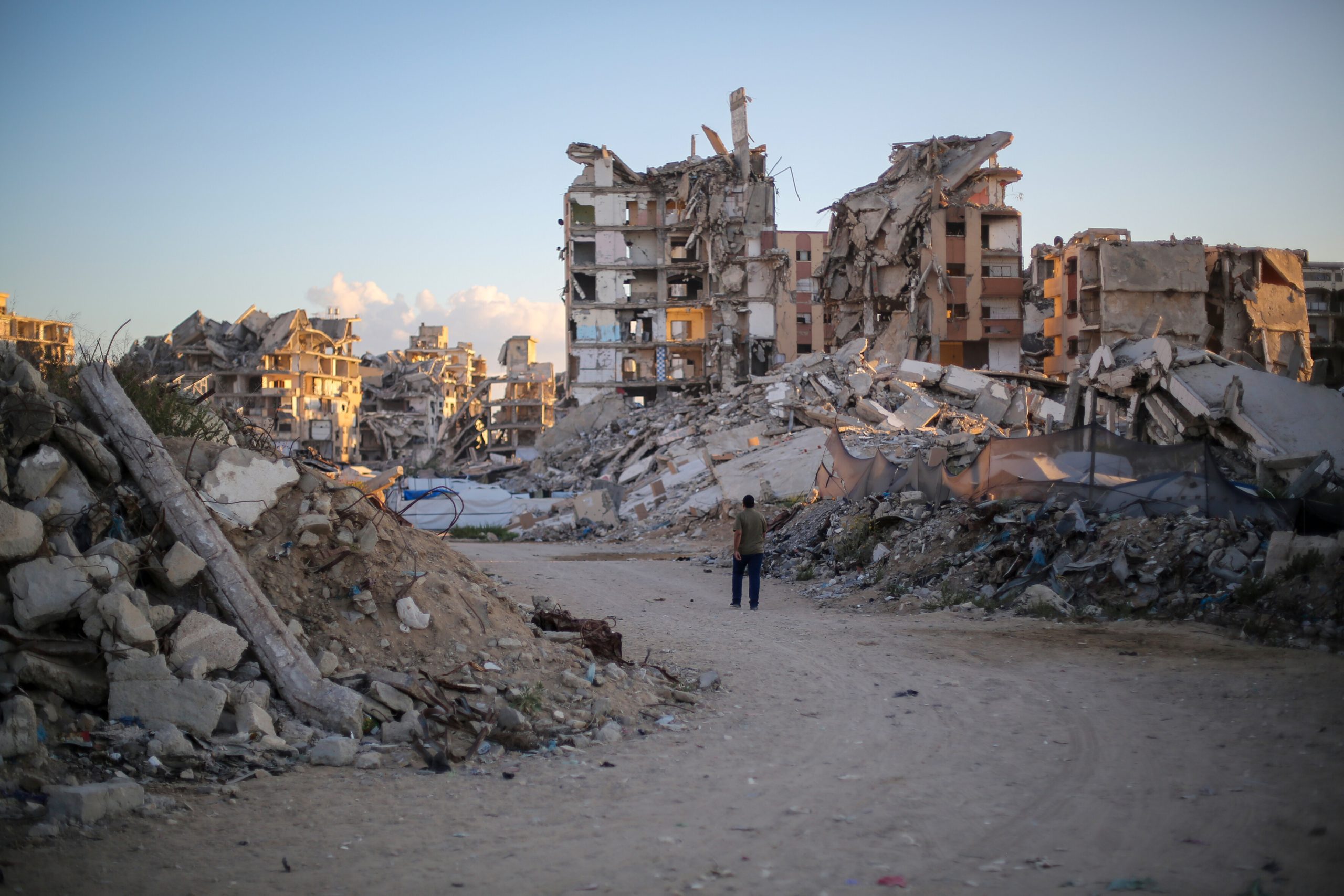 Een man loopt langs gebouwen die op 7 oktober 2026 in Gaza-Stad, Gaz zijn verwoest door Israëlische luchtaanvallen
